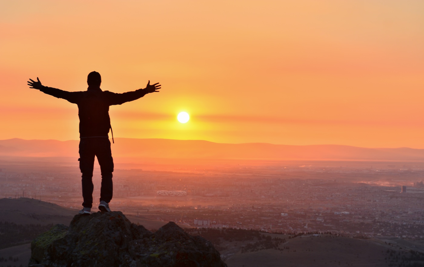 A man open his arms to the sunset